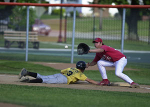 Parkway's Eddie Burtch, left, slides safely back to first base as St. Henry B first baseman Jordan Jacobs, right, awaits the throw during their ACME sectional contest on Wednesday at Veterans Field in Coldwater. Parkway defeated St. Henry B, 15-3, in five innings before losing to Coldwater, 3-2 in the nightcap to get eliminated from summer baseball.<br></br>dailystandard.com