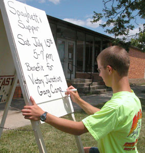 Ian Bruce, a 14-year-old Mendon youth, puts the finishing touches on a sign advertising a fundraiser he is organizing to benefit a camp in North Carolina that helps seriously-ill children.<br></br>dailystandard.com
