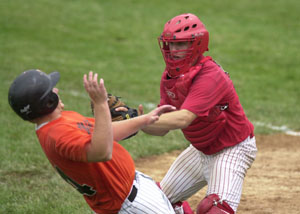 St. Henry catcher Mike Gast, right, tags out Minster's Andrew Baumer, left, at the plate during the fourth inning of their ACME district tournament contest on Wednesday night at Hanover Street Park in Minster. St. Henry won the slugfest over Minster, 12-11.<br></br>dailystandard.com