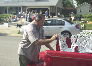 Sidney Smith, Celina, loads an ornamental cast iron lawn set into his pickup this morning. He purchased the set at a garage sale on Magnolia Street in Celina.<br></br>dailystandard.com