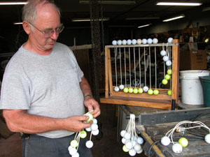 Alvin May unknots several strings of golf balls that must be measured for length before being placed in a game set of hillbilly golf. The St. Henry resident has been creating and selling the popular lawn game for about five years.<br></br>dailystandard.com