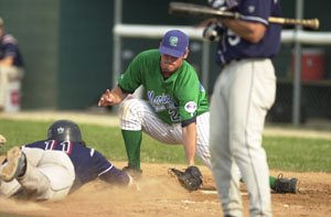 Grand Lake's Adam Abraham, right, waits at home plate to put a tag on Xenia's Blaze Lambert, 11, for an out during the fourth inning of game one of their Great Lakes Summer Collegiate League contest. Abraham got the win on the mound in the first game and helped Grand Lake sweep a doubleheader from Xenia on Wednesday night at Jim Hoess Field, 3-2 and 2-1.<br></br>dailystandard.com