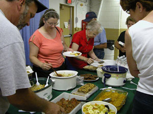 A group of fair patrons dig into a variety of homemade dishes following a demonstration on 