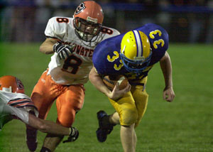 Marion Local's Marc Otte, 33, runs straight ahead as Coldwater's Dusty Rutschilling, 8, reaches out to make the tackle during their Midwest Athletic Conference contest on Friday night.<br></br>dailystandard.com