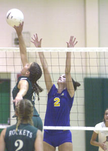 Anna's Lauren Fogt, left, tips the ball past Marion Local's Danielle Langenkamp, 2, during their matchup of top-ranked teams in the state on Tuesday night. Anna, ranked first in Division III, rolled to a three-game win over Marion Local, which is ranked first in Division IV.<br></br>dailystandard.com