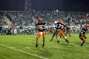 Coldwater quarterback Sam Slavik, 10, surveys the field while teammate Josh Pax, 73, blocks on the offensive line during their game against Anna on Friday night. Slavik threw for 422 yards and four touchdowns to lead the Cavaliers to a 35-19 victory.<br></br>dailystandard.com