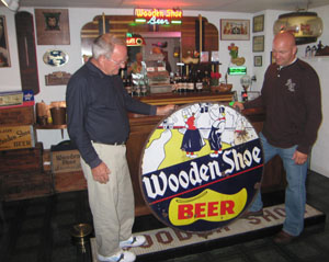 Displaying a porcelain Wooden Shoe sign used to advertize a beer once produced locally are Gene Phlipot, at left, and his son, Andy Phlipot. The Phlipots have acquired rights to the name and will bring it back to the marketplace.<br></br>dailystandard.com