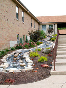 Water flows down a 100-foot stream along the front walkway of the Spiritual Center of Maria Stein as part of a memorial garden constructed in the memory of Brother Bernie Barga. Barga, a member of the Missionaries of the Precious Blood, died in December 2001. His work as a retreat leader at the Spiritual Center is being memorialized by the waterfall and garden. See story and more pics on page 9A.<br></br>dailystandard.com