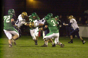 Celina's A.J. Mast, 3, tries to rip the ball away from Bath running back Todd Ruggley, with ball, while Brandon Koontz, 72, comes in to help out on the play during their Western Buckeye League game on Friday night at Celina Stadium. Bath defeated Celina, 21-7, on homecoming night for the Bulldogs.<br></br>dailystandard.com
