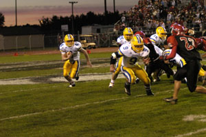 St. Marys' Koby Frye, left, looks to follow blocks from teammates Scott Laman, 9, and Dustin Arnold, 75, during their Western Buckeye League contest against Lima Shawnee on Friday night. St. Marys pulled off an upset over Shawnee as the Roughriders defeated the Indians, 10-0.<br></br>dailystandard.com