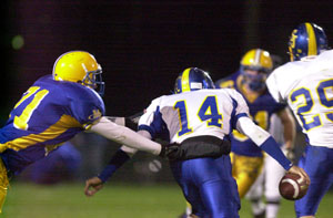 Marion Local's Cody Wynk, left, closes in to make a tackle on Delphos St. John's quarterback Nick Johnson, 14, during their Midwest Athletic Conference contest on Friday.<br></br>dailystandard.com