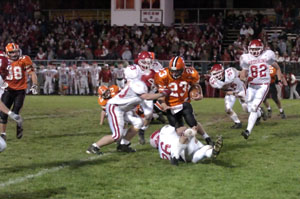 Versailles quarterback Tony McNeilan is tied up by a group of St. Henry defenders during Friday's MAC game at Hole Field in Versailles. The Redskins routed the Tigers 51-8.<br></br>dailystandard.com