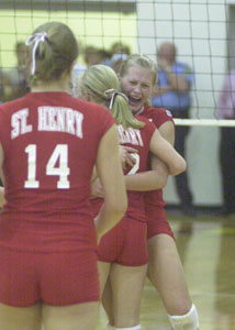 St. Henry's Bethany Puthoff, back, hugs teammate Kendra Rutschilling after the Redskins upset top-ranked Marion Local in five games on Tuesday night at New Bremen High School. St. Henry won 25-22, 10-25, 25-23, 15-25 and 15-11. The Redskins will now play New Knoxville on Thursday at 7 p.m. back at New Bremen. <br></br>dailystandard.com