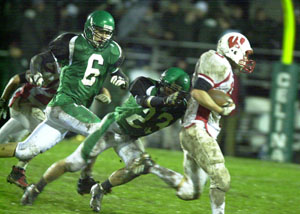 Celina's Kane Swaney, 23, reaches out to tackle a Wapakoneta ball carrier as Bulldog teammate Dustin Grinstead, 6, pursues on the play during their Western Buckeye League contest at Celina Stadium on Friday night.  Wapakoneta clinched the outright WBL title with a 34-6 win over Celina.<br></br>dailystandard.com
