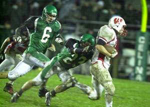 Celina's Kane Swaney, 23, reaches out to tackle a Wapakoneta ball carrier as Bulldog teammate Dustin Grinstead, 6, pursues on the play during their Western Buckeye League contest at Celina Stadium on Friday night. Wapakoneta clinched the outright WBL title with a 34-6 win over Celina.<br></br>dailystandard.com