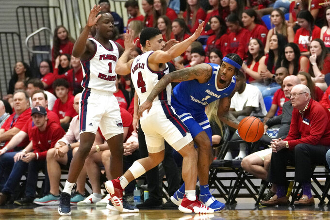 Middle Tennessee forward Tyler Millin (1) looks to pass the ball as Florida Atlantic guard Johnell Davis, left, and guard Bryan Greenlee (4) defend during the first half of an NCAA college basketball game Thursday, Jan. 26, 2023, in Boca Raton, Fla. (AP Photo/Lynne Sladky)