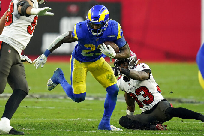 Los Angeles Rams running back Cam Akers (23) slips a tackle by Tampa Bay Buccaneers free safety Jordan Whitehead (33) during the second half of an NFL divisional round playoff football game Sunday, Jan. 23, 2022, in Tampa, Fla. (AP Photo/John Raoux)