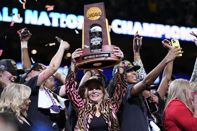 FILE - LSU head coach Kim Mulkey holds the winning trophy after the NCAA Women's Final Four championship basketball game against Iowa Sunday, April 2, 2023, in Dallas. LSU won 102-85 to win the championship. (AP Photo/Tony Gutierrez, File)