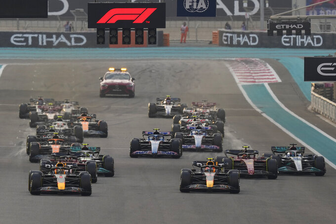 Red Bull driver Max Verstappen of the Netherlands, left, and Red Bull driver Sergio Perez of Mexico lead at the start during the Formula One Abu Dhabi Grand Prix, in Abu Dhabi, United Arab Emirates Sunday, Nov. 20, 2022. (AP Photo/Hussein Malla)