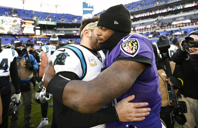 Baltimore Ravens quarterback Lamar Jackson, right, hugs Carolina Panthers quarterback Baker Mayfield, left, after an NFL football game Sunday, Nov. 20, 2022, in Baltimore. (AP Photo/Nick Wass)