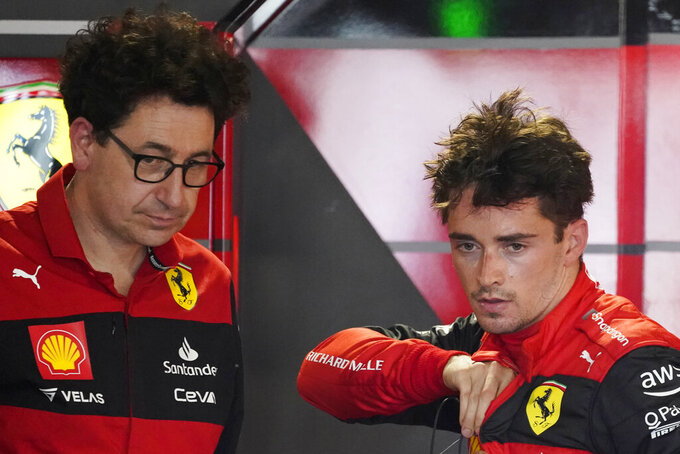 FILE - Ferrari driver Charles Leclerc of Monaco speaks with Ferrari team principal Mattia Binotto following the first practice session for the Formula One Miami Grand Prix auto race at the Miami International Autodrome, on May 6, 2022, in Miami Gardens, Fla. Ferrari team principal Mattia Binotto is leaving the team at the end of next month after four years in which they often struggled to keep up with Formula One’s leaders. Binotto has been with Ferrari for 28 years and took over the team principal role in 2019. The team was winless in 2020 and 2021. It started 2022 promisingly as Charles Leclerc won two of the opening three races. (AP Photo/Darron Cummings)