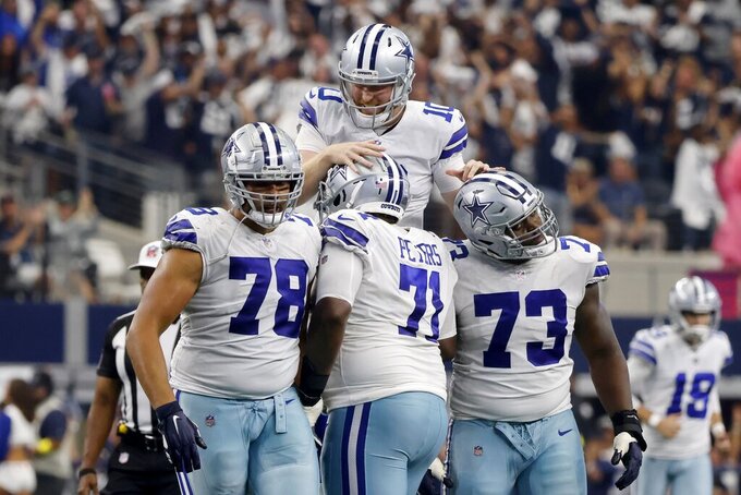 Dallas Cowboys quarterback Cooper Rush celebrates throwing a touchdown pass with Terence Steele (78), Jason Peters (71), and Tyler Smith (73) in the second half of a NFL football game against the Washington Commanders in Arlington, Texas, Sunday, Oct. 2, 2022. (AP Photo/Michael Ainsworth)