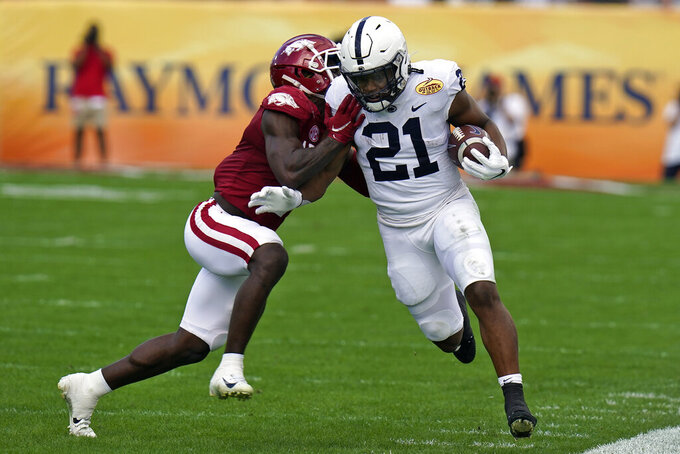 Penn State running back Noah Cain (21) gets shoved out of bounds by Arkansas defensive back Joe Foucha during the first half of the Outback Bowl NCAA college football game Saturday, Jan. 1, 2022, in Tampa, Fla. (AP Photo/Chris O'Meara)