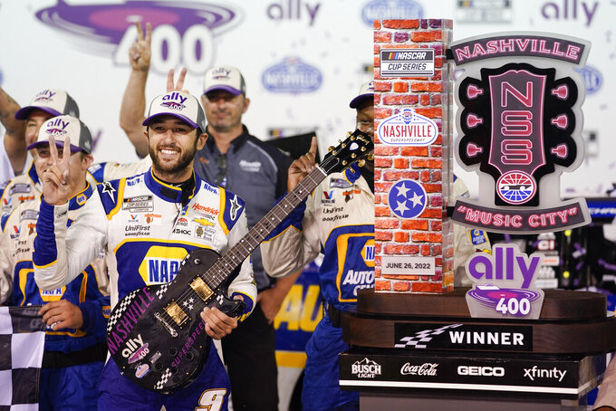 Chase Elliott poses with his guitar and trophy after winning a NASCAR Cup Series auto race Sunday, June 26, 2022, in Lebanon, Tenn. (AP Photo/Mark Humphrey)