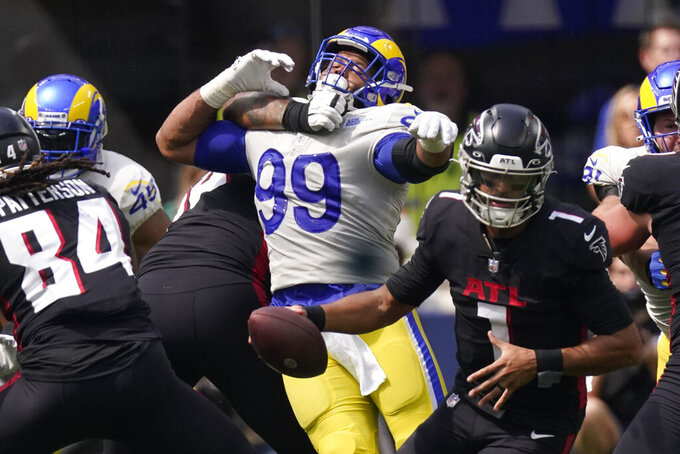 Los Angeles Rams defensive tackle Aaron Donald (99) is kept away from Atlanta Falcons quarterback Marcus Mariota (1) by Atlanta Falcons offensive tackle Elijah Wilkinson during the first half of an NFL football game Sunday, Sept. 18, 2022, in Inglewood, Calif. (AP Photo/Mark J. Terrill)