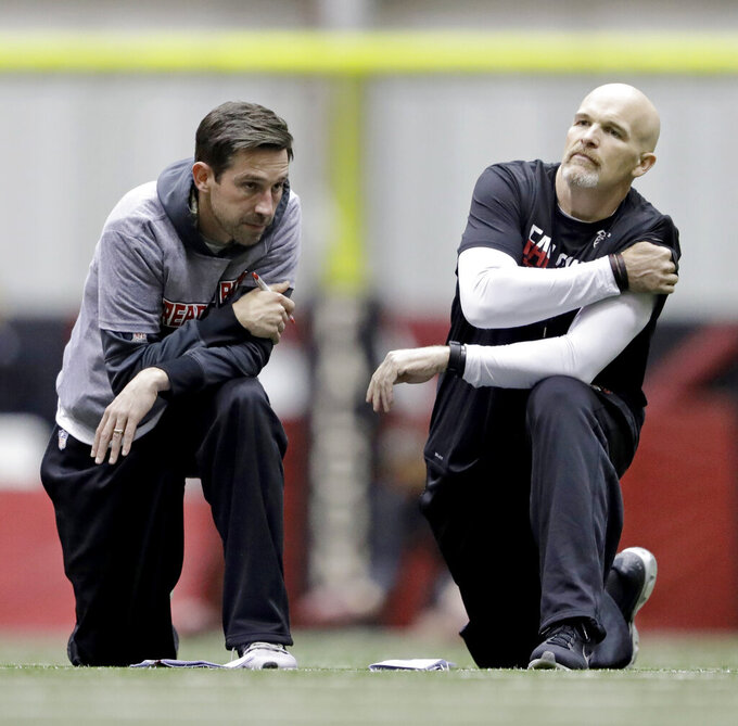 FILE - Atlanta Falcons head coach Dan Quinn, right, talks with offensive coordinator Kyle Shanahan during a workout at the NFL football team's practice facility in Flowery Branch, Ga., Friday, Jan. 27, 2017. Kyle Shanahan and Dan Quinn will always share the painful memory of coaching in the Super Bowl together with Atlanta five years ago when the Falcons couldn't hold a 25-point lead in the second half of a loss to New England. The wild-card meeting Sunday, Jan. 16, 2022 between the visiting 49ers (10-7) and Cowboys (12-5) is the first in the playoffs involving both coaches since that crushing loss in Houston.(AP Photo/David Goldman, File)