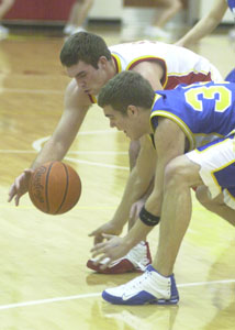 New Bremen's Jeff Thobe, in white, and Marion Local's Wes Everman, in blue, chase a loose ball during Monday's contest. New Bremen defeated Marion Local, 57-42.<br>dailystandard.com