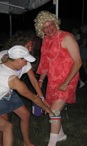 Mayor Madonna, known to constituents as New Bremen Mayor Jeff Pape, smiles as supporters Suann Luedeke and Karen Westerbeck tuck dollar bills into his garter during a Friday night competion. The event was staged to raise money for the American Cancer Society at the Southwestern Auglaize County Relay for Life. Pape was among a number of men who donned female attire in order to vie for the queen's crown.<br>dailystandard.com
