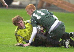 Celina's Brian Dorsten, 11, gets tangled up with Findlay goal keeper Todd Geise, left, during their Division I sectional match on Thursday at Graham Memorial Stadium in Findlay. Celina was beaten by the host Trojans, 1-0 in two overtimes.<br></br>dailystandard.com
