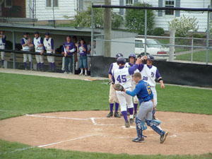 Fort Recovery's Tony Diller, 28, is among the teammates congratulating Steve Trobridge, 45, after his three-run home run in the first inning of Saturday's game at Minster against Waynesfield-Goshen.<br></br>dailystandard.com