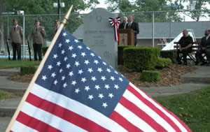 Coldwater Mayor Lavern Stammen is flanked by former village Mayor Maurice Cron as he gives a brief speech during Memorial Day services Monday at Coldwater Memorial Park. Members of the American Legion and Veterans of Foreign Wars, auxiliary units, the Coldwater High School Band, the local Civil Air Patrol, Boy and Girl Scout troops and local clergymen also were on hand for the patriotic ceremony.<br></br>dailystandard.com