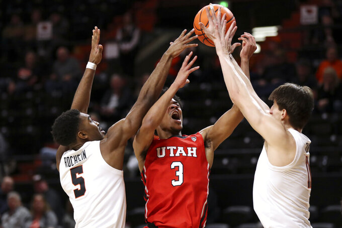 Utah forward Bostyn Holt, center, has his shot blocked as Oregon State's Justin Rochelin, left, and Dzmitry Ryuny, right, defend during the second half of an NCAA college basketball game in Corvallis, Ore., Thursday, Jan. 26, 2023. Utah won 63-44. (AP Photo/Amanda Loman)