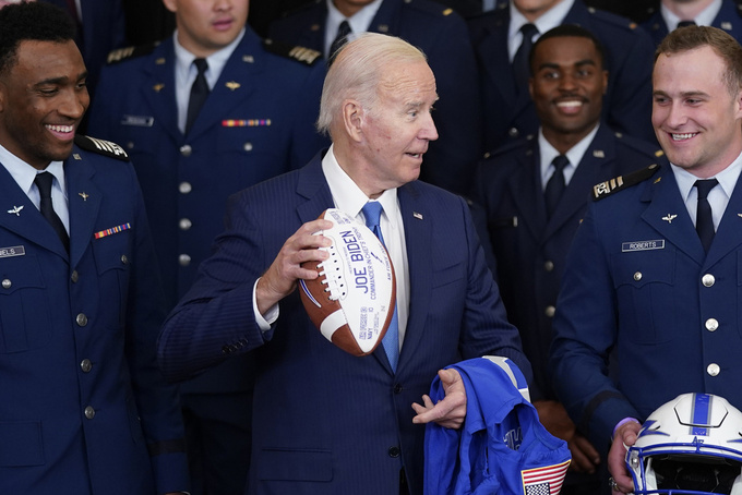 FILE - Air Force quarterback Haaziq Daniels, left, and Air Force running back Brad Roberts, right, look on as President Joe Biden holds a football during an event to present the Commander-in-Chief's trophy to the Air Force Academy in the East Room of the White House, Friday, April 28, 2023, in Washington. (AP Photo/Evan Vucci, File)