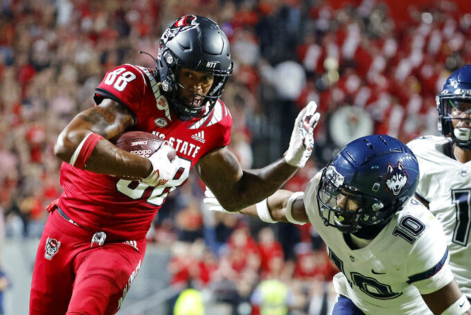 North Carolina State's Devin Carter (88) prepares to stiff-arm Connecticut's Chris Shearin (10) following a reception during the first half of an NCAA college football game in Raleigh, N.C., Saturday, Sept. 24, 2022. (AP Photo/Karl B DeBlaker)
